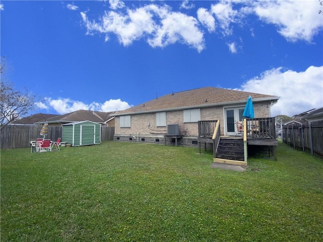 rear view of house with an outbuilding, cooling unit, a shed, a wooden deck, and a fenced backyard