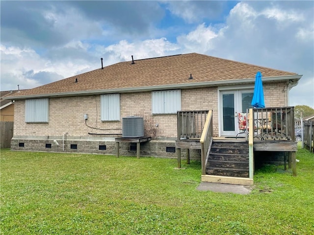 rear view of property with brick siding, cooling unit, french doors, and a yard