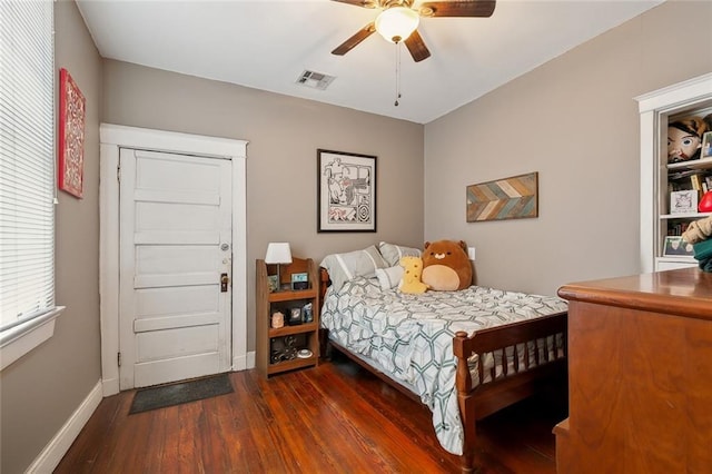 bedroom featuring dark wood-style floors, visible vents, ceiling fan, and baseboards