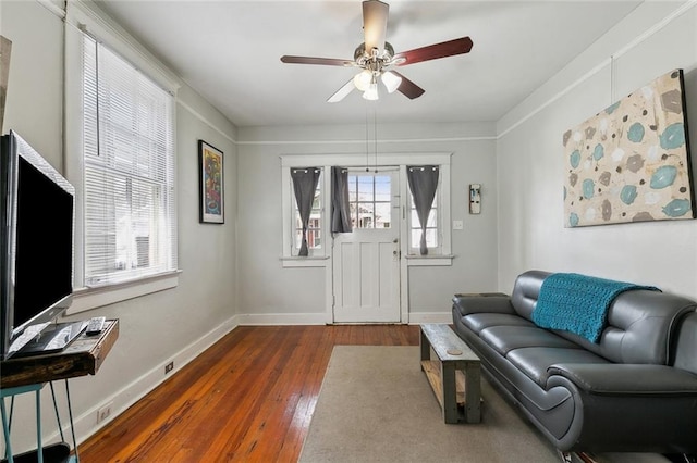 living room featuring baseboards, dark wood-type flooring, and ceiling fan