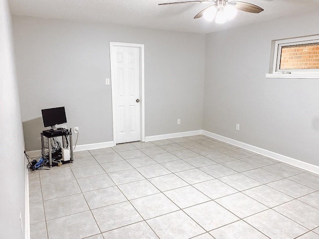 unfurnished room featuring baseboards, a textured ceiling, and ceiling fan