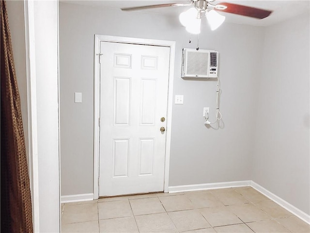 doorway to outside featuring baseboards, light tile patterned flooring, a ceiling fan, and a wall unit AC