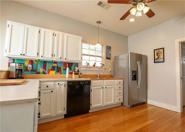 kitchen featuring visible vents, ceiling fan, black dishwasher, stainless steel refrigerator with ice dispenser, and a sink