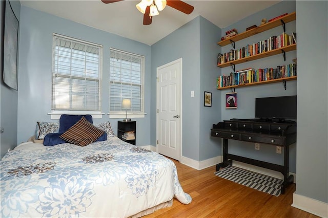 bedroom featuring a ceiling fan, baseboards, and wood finished floors