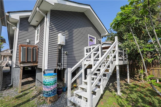 view of side of home featuring stairway and fence