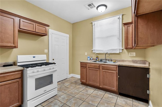 143537 France St, New Orleans, LA 70117 - kitchen with white gas range, visible vents, light countertops, and a sink