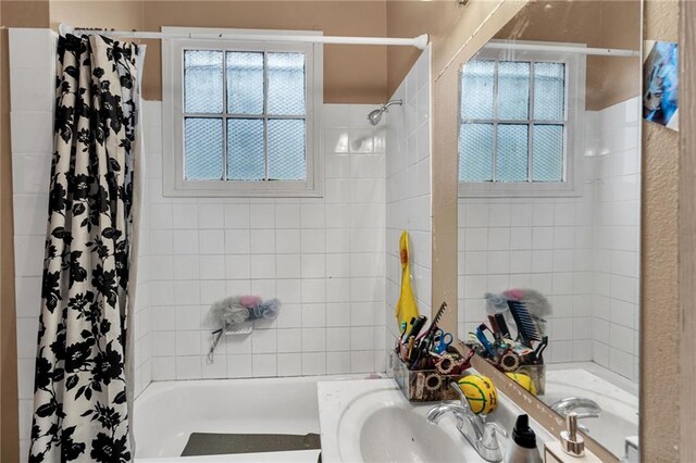 143537 France St, New Orleans, LA 70117 - bathroom featuring vanity, a healthy amount of sunlight, and shower / tub combo with curtain