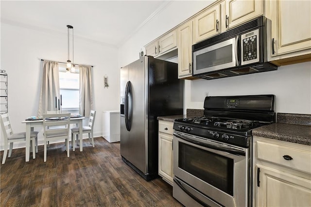 kitchen with dark wood-style floors, baseboards, hanging light fixtures, cream cabinetry, and appliances with stainless steel finishes