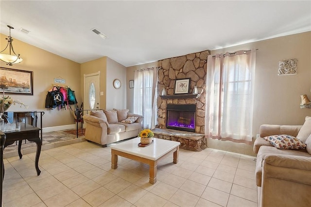 living area with light tile patterned floors, a fireplace, visible vents, and baseboards