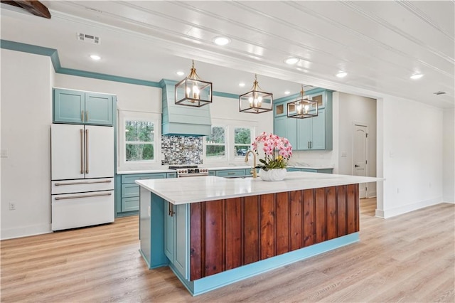 kitchen with high end white refrigerator and blue cabinets