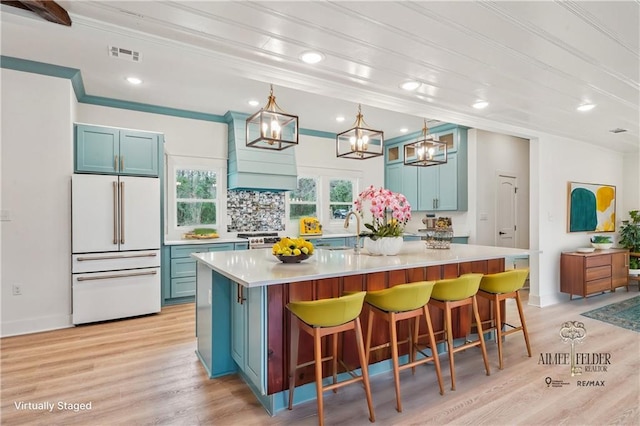 kitchen featuring high end fridge, visible vents, and blue cabinetry