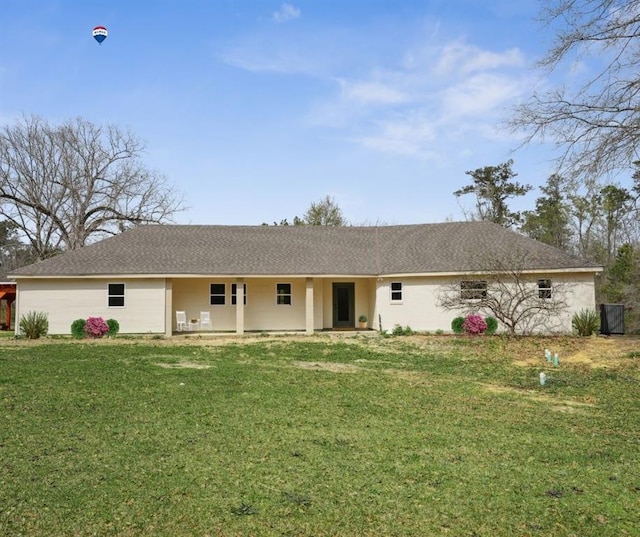ranch-style house featuring a shingled roof and a front yard