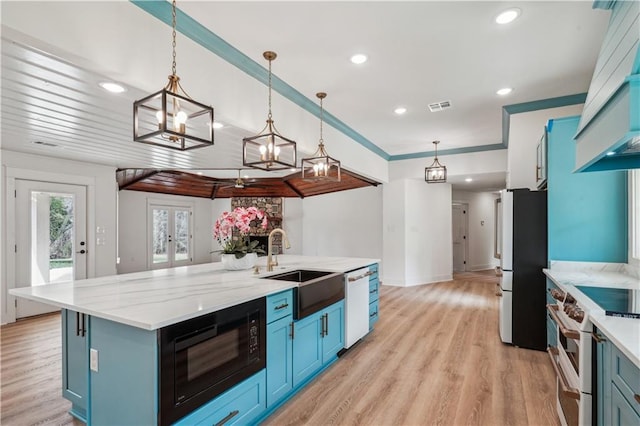 kitchen with visible vents, a sink, white appliances, a center island with sink, and blue cabinetry