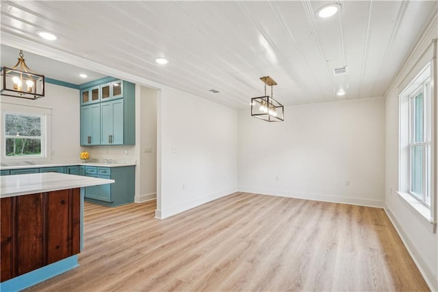 unfurnished dining area with plenty of natural light, visible vents, light wood-type flooring, and a notable chandelier