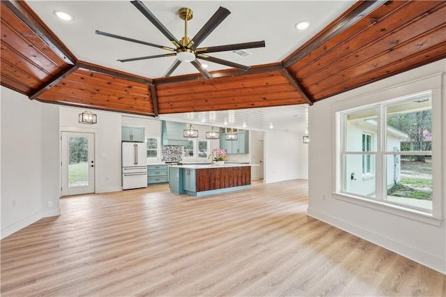 unfurnished living room featuring light wood-type flooring, plenty of natural light, and a ceiling fan