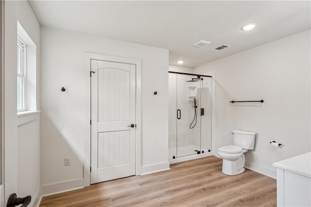 full bath featuring a shower stall, toilet, baseboards, and wood finished floors