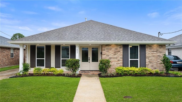 view of front of property with a front yard, brick siding, and roof with shingles