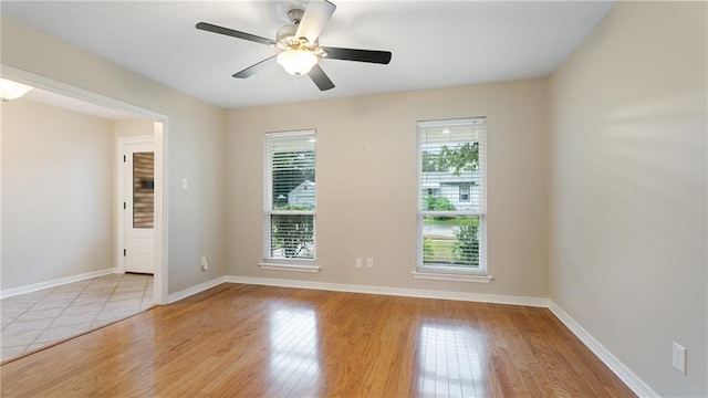 empty room with light wood finished floors, ceiling fan, and baseboards