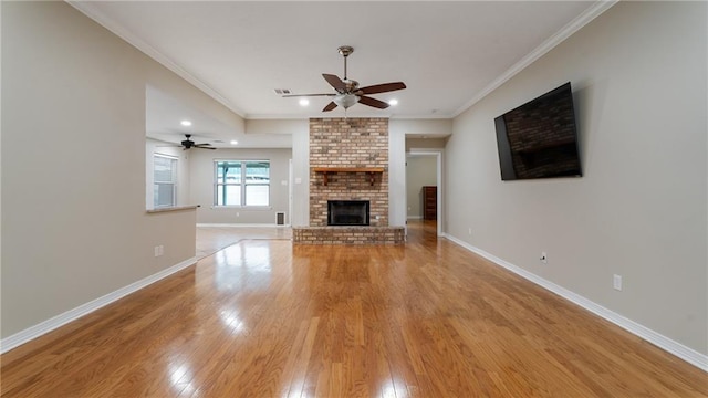 unfurnished living room with ornamental molding, a ceiling fan, light wood-type flooring, and baseboards