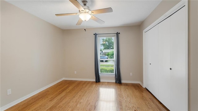unfurnished bedroom with ceiling fan, a closet, baseboards, and light wood-style flooring