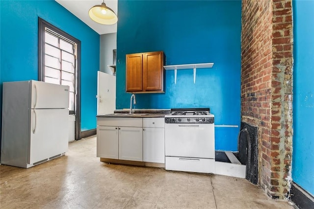 kitchen with dark countertops, white appliances, a fireplace, and a sink