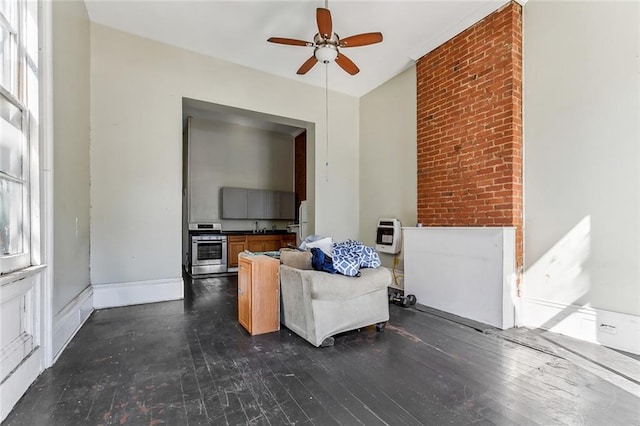 sitting room featuring baseboards, a ceiling fan, dark wood-style flooring, and a healthy amount of sunlight