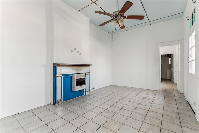 unfurnished living room with heating unit, a fireplace, and ceiling fan