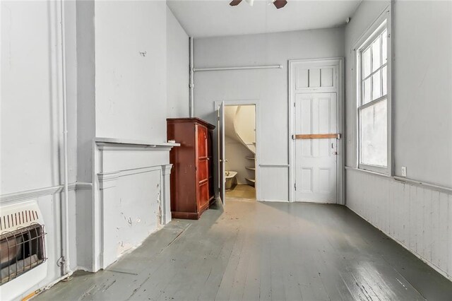 spare room with heating unit, ceiling fan, and hardwood / wood-style flooring