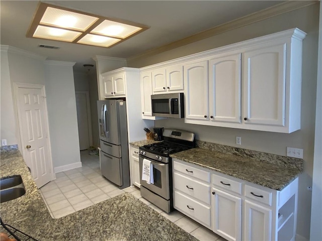 kitchen featuring visible vents, dark stone counters, ornamental molding, appliances with stainless steel finishes, and white cabinetry