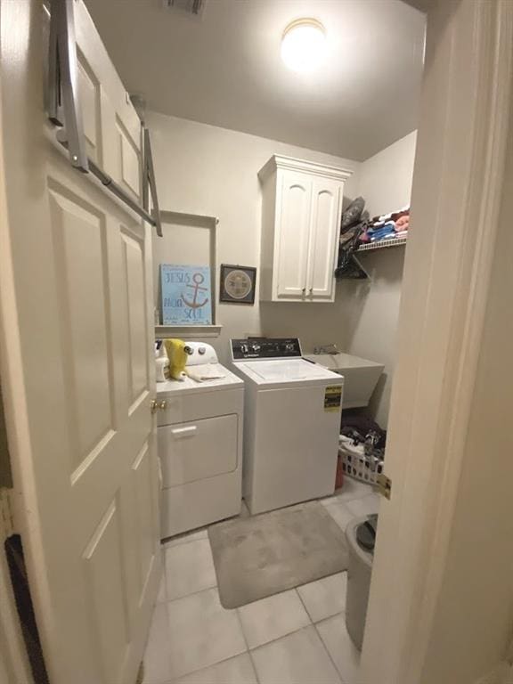 laundry area featuring visible vents, independent washer and dryer, a sink, cabinet space, and light tile patterned floors