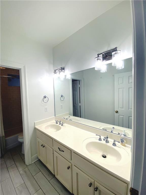 full bath featuring a sink, toilet, tub / shower combination, and double vanity