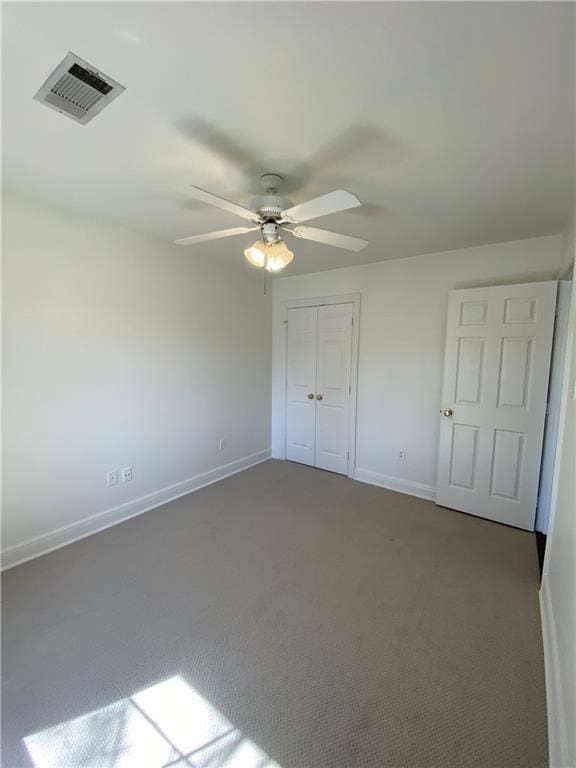 unfurnished bedroom with visible vents, a ceiling fan, a closet, carpet floors, and baseboards