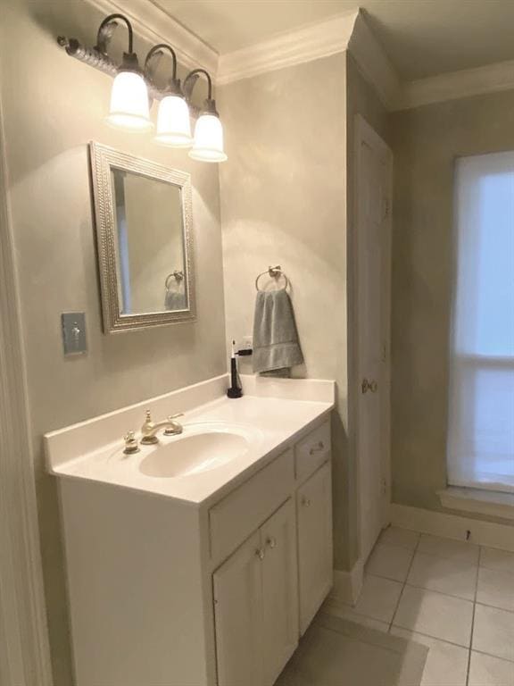 bathroom with tile patterned flooring, crown molding, vanity, and baseboards