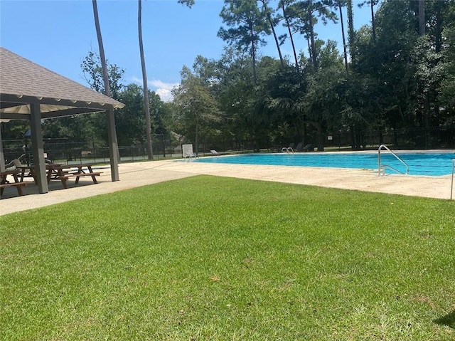 pool with a gazebo, a lawn, and fence