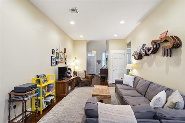 living area with dark wood finished floors, visible vents, recessed lighting, and baseboards