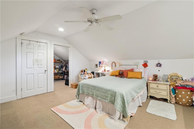 bedroom featuring a ceiling fan, lofted ceiling, a spacious closet, a closet, and light carpet