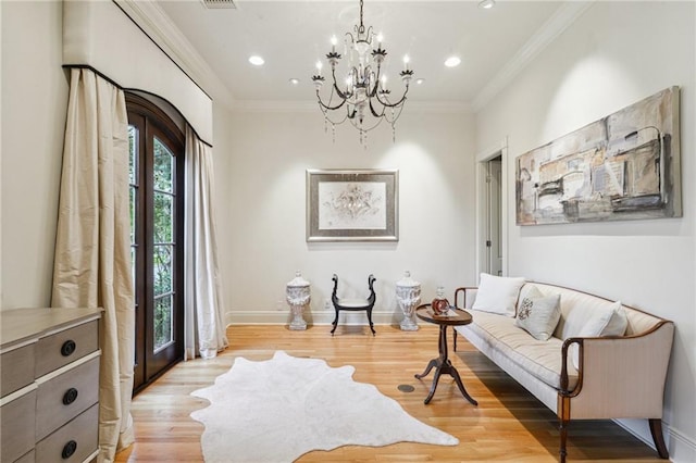 sitting room featuring light wood finished floors, baseboards, ornamental molding, recessed lighting, and a notable chandelier