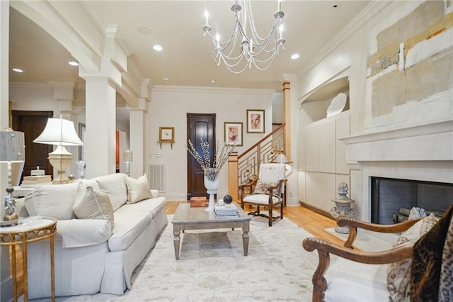 living room featuring wood finished floors, visible vents, an inviting chandelier, ornamental molding, and stairs