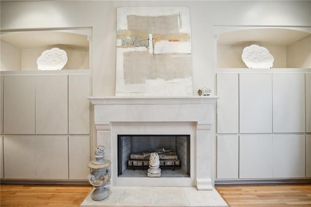 details featuring a fireplace with flush hearth and wood finished floors