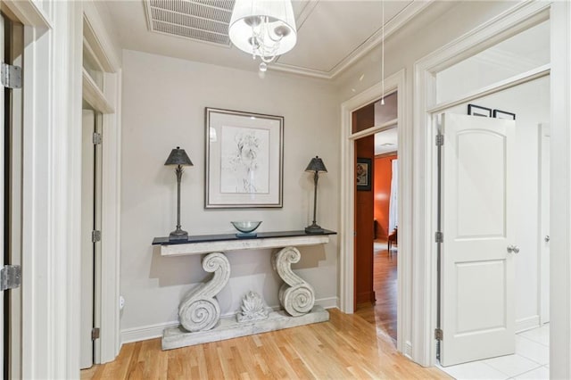 hall featuring visible vents, attic access, baseboards, and wood finished floors