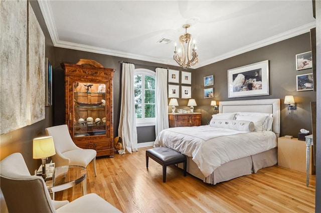 bedroom featuring a notable chandelier, visible vents, crown molding, and light wood-style floors