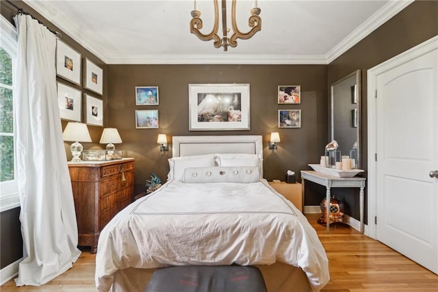 bedroom featuring light wood-style floors, a notable chandelier, and ornamental molding