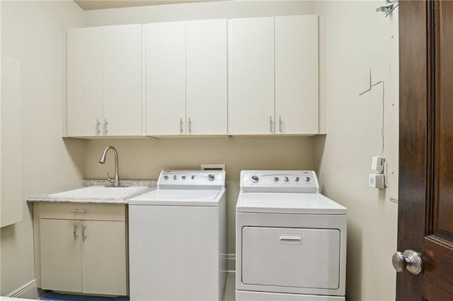 laundry area with cabinet space, independent washer and dryer, and a sink