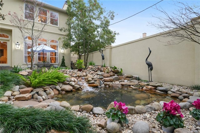 view of yard with a small pond and fence