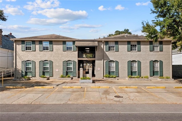 view of front of property with brick siding and uncovered parking