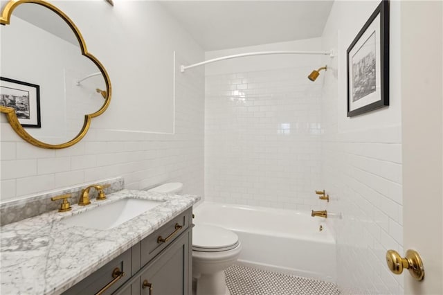 bathroom with tile patterned flooring, toilet, vanity, bathtub / shower combination, and tile walls