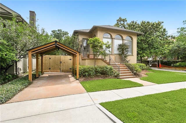 30 Neron Pl, New Orleans, LA 70118 - view of front of property featuring a gate, concrete driveway, a front lawn, stucco siding, and a detached carport