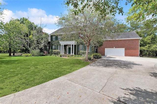 115 Cambridge Dr, Belle Chasse, LA 70037 - view of front of home featuring concrete driveway, brick siding, a front lawn, and a garage