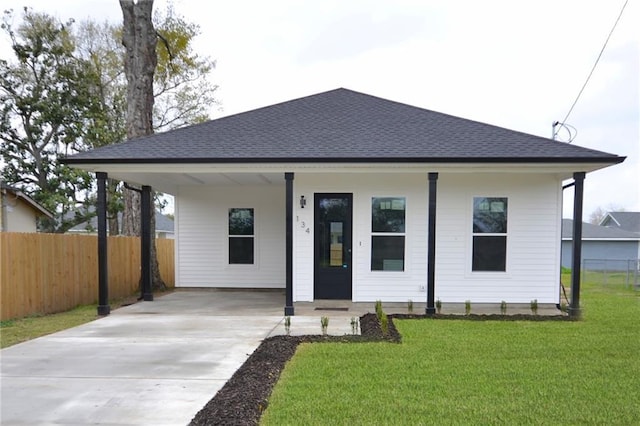 134 Gourgues St, Hahnville, LA 70057 - bungalow-style home with fence, an attached carport, roof with shingles, a front lawn, and concrete driveway