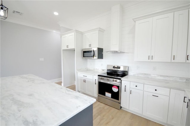 134 Gourgues St, Hahnville, LA 70057 - kitchen featuring white cabinets, light wood-style flooring, visible vents, stainless steel appliances, and wall chimney exhaust hood